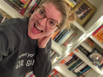 Host Kristen Coates in front of her bookshelf